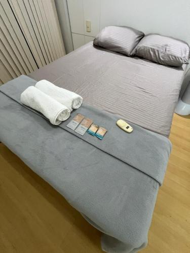 a bed with two pillows and towels on it at Flat shopping Ibituruna in Montes Claros