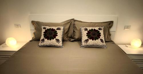 a bed with two pillows and two lamps on it at ferrari stay - comfortable two-room apartment in Maranello