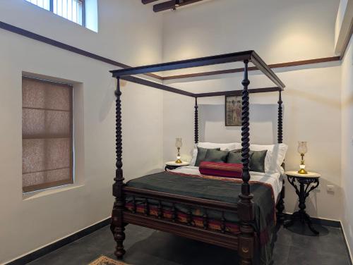 a bedroom with a canopy bed with two lamps at Nilayam by Luxunlock Private Villas in Jāmb