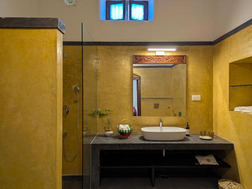 a bathroom with a sink and a mirror at Nilayam by Luxunlock Private Villas in Jāmb
