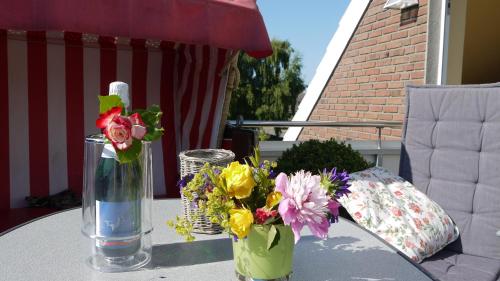 a table with a vase of flowers on a patio at Inselferien Micheel in Burg auf Fehmarn