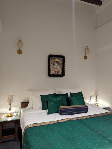 a bedroom with a bed with green and white sheets at Nilayam by Luxunlock Private Villas in Jāmb