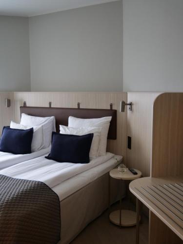 a bedroom with a large bed with blue pillows at Quality Hotel Arlanda XPO in Arlanda