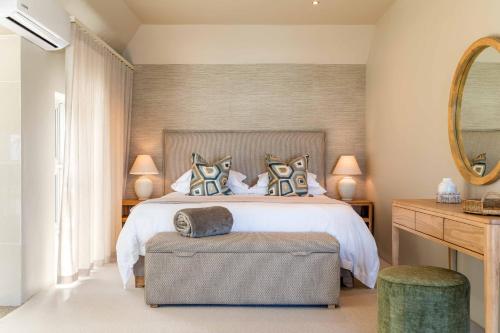 a bedroom with a large bed and a mirror at SEASENSE Boutique Beach Villa in Wilderness