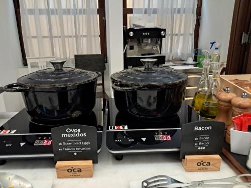 two black pots sitting on top of a counter at Oca Ribeira do Porto AT in Porto