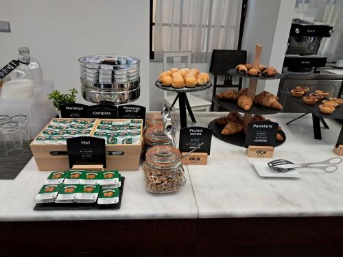 a table with a bunch of pastries and other foods at Oca Ribeira do Porto AT in Porto