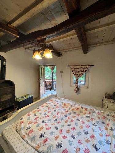 a bedroom with a bed with a colorful comforter at Stillwood Retreat-Off-Grid Nature Escape in Certeju de Jos