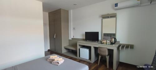 Nathon BayにあるChaweng Town Hotelのデスク、パソコン、鏡が備わる客室です。
