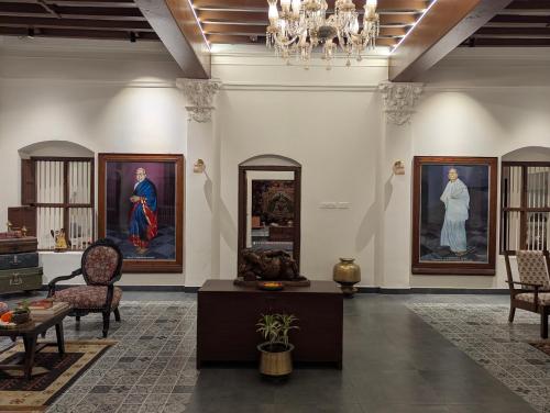a room with paintings on the wall and a table at Nilayam by Luxunlock Private Villas in Jāmb