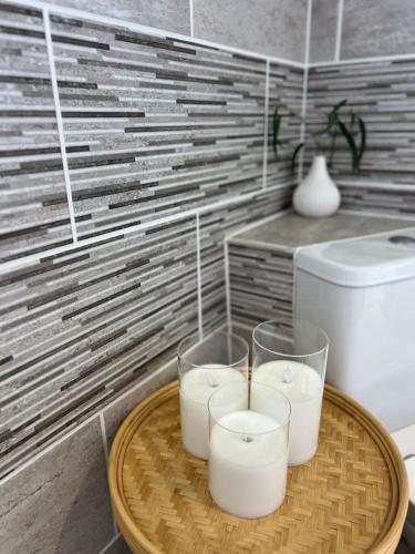 a tray with three candles on a table in a bathroom at Stunning and Peaceful 2 bed Flat 10 mins from Stansted Airport in Stansted Mountfitchet