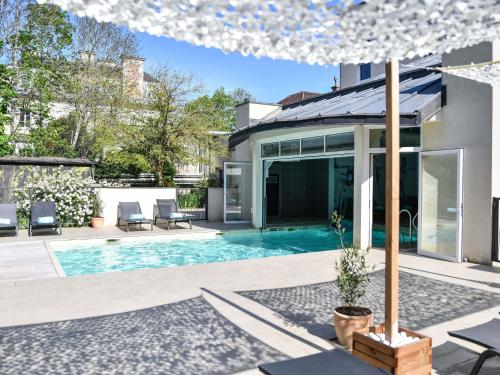 a swimming pool in the backyard of a house at Hotel Mercure Château de Fontainebleau in Fontainebleau
