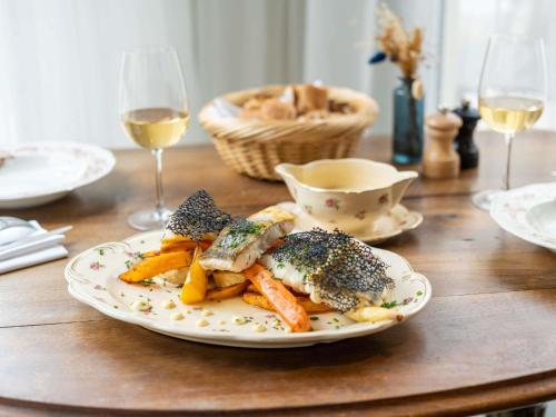 a plate of food with vegetables on a wooden table at Hotel Mercure Château de Fontainebleau in Fontainebleau