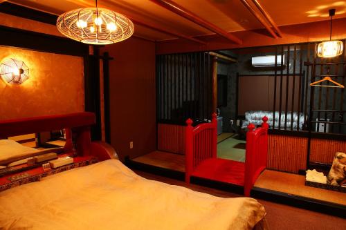 a bedroom with a bed and a chair in it at ホテルサルビア in Tendo