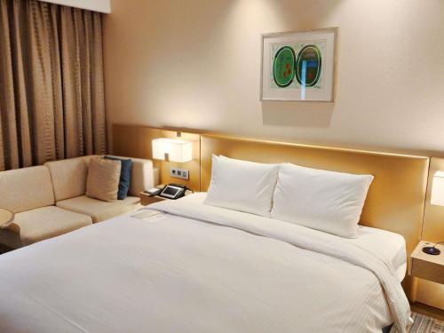 a hotel room with a bed and a couch at Novotel Ambassador Seoul Gangnam in Seoul