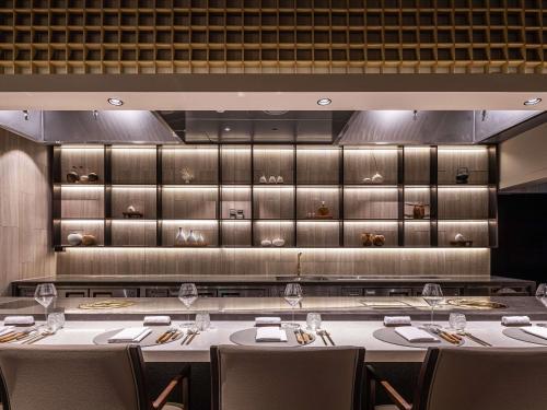 a restaurant with tables and chairs in a room at Novotel Ambassador Seoul Gangnam in Seoul