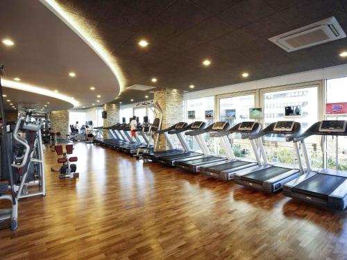 a gym with a row of treadmills and machines at Novotel Ambassador Seoul Gangnam in Seoul