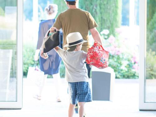 a young boy holding a hat and shopping bags at Novotel Ambassador Seoul Gangnam in Seoul