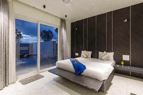 una camera da letto con un letto e una grande finestra di Diamond Blue Pool Villa Private Pool Veg Food a Dod Ballāpur
