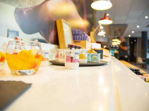 a person is sitting at a counter with a drink at ibis Mulhouse Centre Filature in Mulhouse