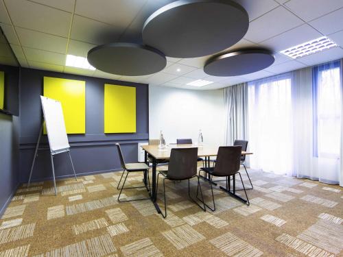 a conference room with a table and chairs at ibis Mulhouse Centre Filature in Mulhouse