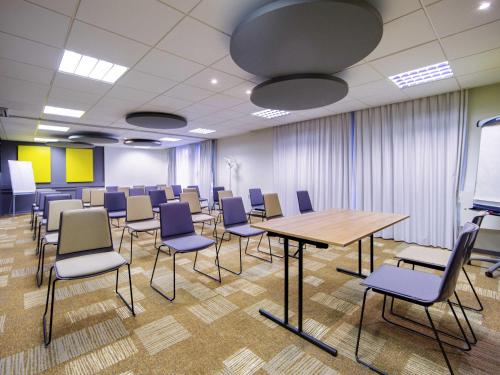 a conference room with a table and chairs at ibis Mulhouse Centre Filature in Mulhouse