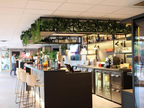a restaurant with a bar with stools at ibis Aubenas in Aubenas