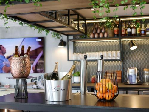 a counter with bottles of champagne and fruit on it at ibis Aubenas in Aubenas