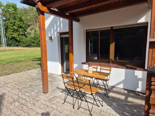 a table and chairs on the patio of a house at Alte Ölmühle im Herzen des Thüringer Waldes in Friedrichroda