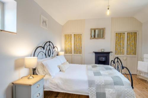 ein Schlafzimmer mit einem Bett und einem Tisch mit einer Lampe in der Unterkunft Carrstone Cottage in Grimston