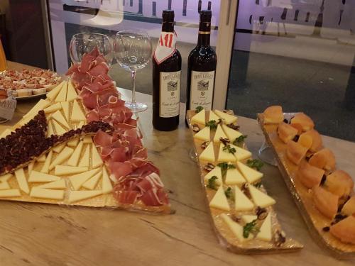 a table with two bottles of wine and cheese and wine glasses at ibis Bayonne Centre in Bayonne
