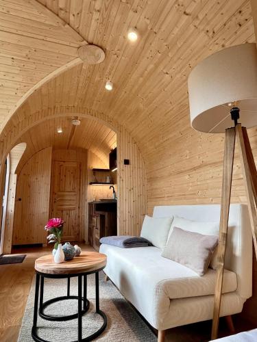 a living room with a white couch and a table at Caravanserei Resort Oberhavel in Oranienburg