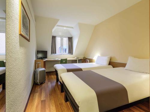 a hotel room with two beds and a television at ibis Hotel Erfurt Altstadt in Erfurt