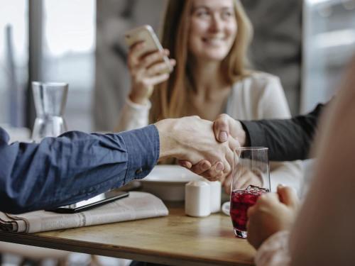 a group of people sitting around a table holding hands at ibis Hotel Erfurt Altstadt in Erfurt