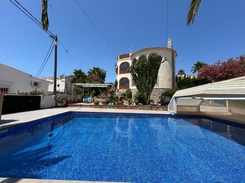 a swimming pool in front of a house at Chalet Los Almendros con piscina privada in Calpe