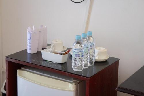a table with bottles of water on top of a refrigerator at Sorabora Gedara Hotel in Mahiyangana