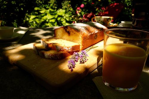 a sandwich on a cutting board next to a glass of orange juice at Bed & Breakfast Uvablu in Trontano