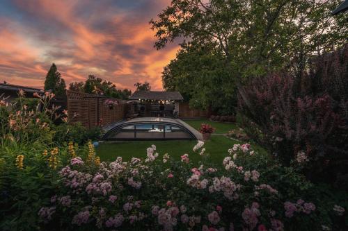 a house with a garden with flowers in the yard at Lubi Lodge in Balatonboglár