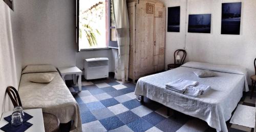a small room with two beds and a window at Aghinas in Bosa