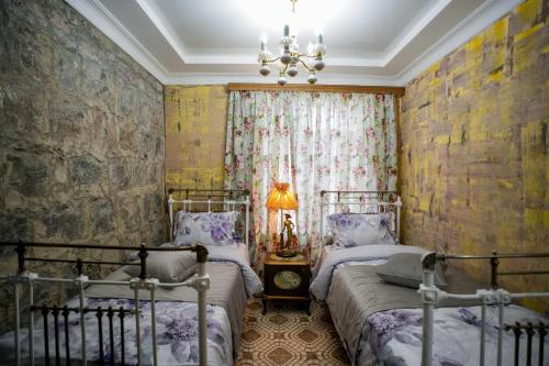 a bedroom with two beds and a chandelier at The Victorian Hotel & Spa Room 3 in Yerevan