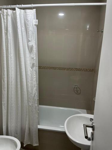 a bathroom with a white tub and a sink at Departamento Rodriguez in Bahía Blanca