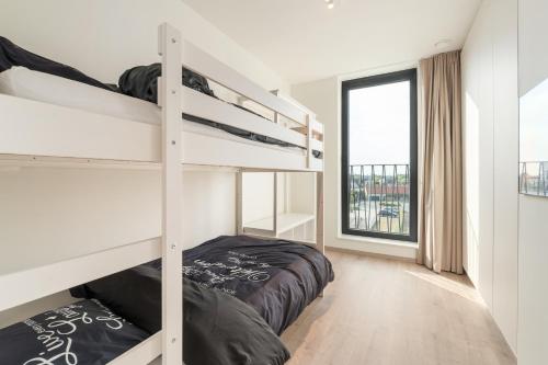 a bedroom with two bunk beds and a window at Dunique 0302 in Bredene-aan-Zee