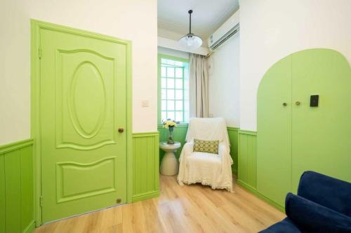 a green door in a room with a chair at 柃居 B&B - Jing'an Temple Branch in Shanghai