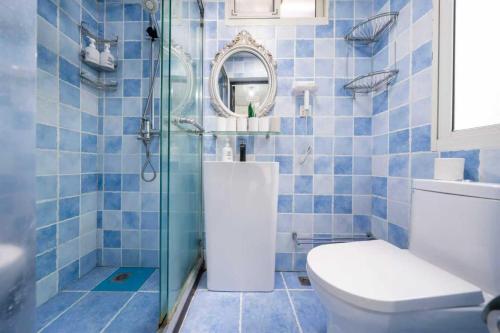 a blue tiled bathroom with a toilet and a shower at 柃居 B&B - Jing'an Temple Branch in Shanghai