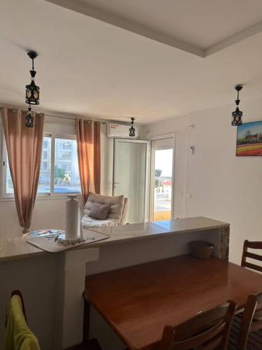 a kitchen and living room with a table and a couch at Appartement F2 Résidence Belvédère Vue Mer et Piscine Bejaia in Bejaïa