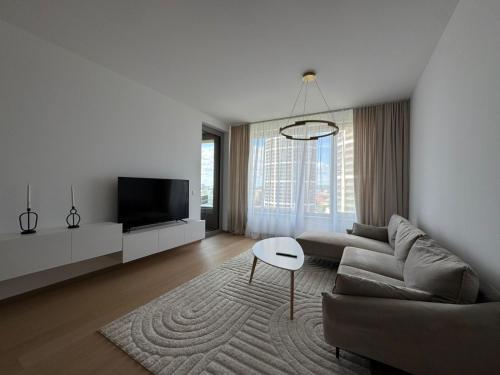 NivyにあるSkau Sky Park Ivory by Zaha Hadid 11 Floor 4 Tower Free Parkingのソファとテレビのあるリビングルーム