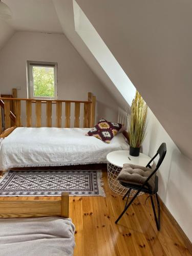 a bedroom with a bed and a table and a chair at Wzgórze Artystów in Głuszyca