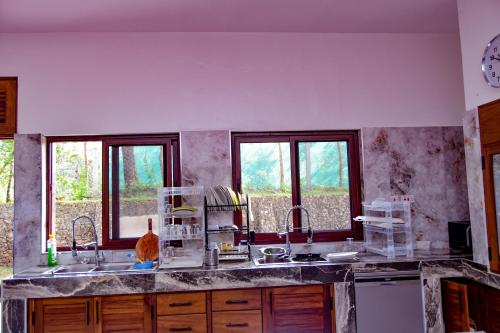 a kitchen with two sinks and two windows at Rozzies Beach Villa Malindi in Malindi