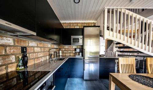 a kitchen with blue cabinets and a stainless steel refrigerator at Villa Marrikka, Levi in Levi