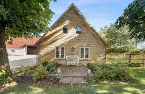 a brick house with a chair in front of it at Large Holiday Home With Pool On South Lolland Coast in Dannemare