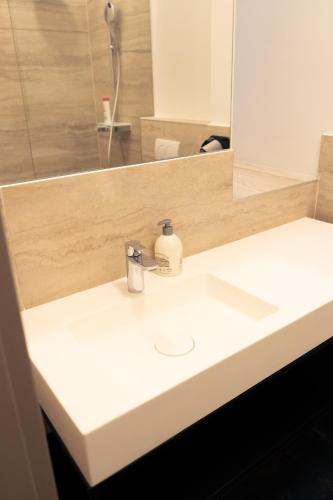 a bathroom sink with a soap dispenser on it at Elias Residence Vienna in Vienna